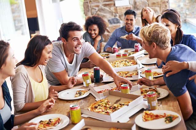 Lunch, happy friends and pizza party with food, drinks and conversation, social gathering and get together. Young people, group and happiness at fast food pizzeria, restaurant and celebration at home