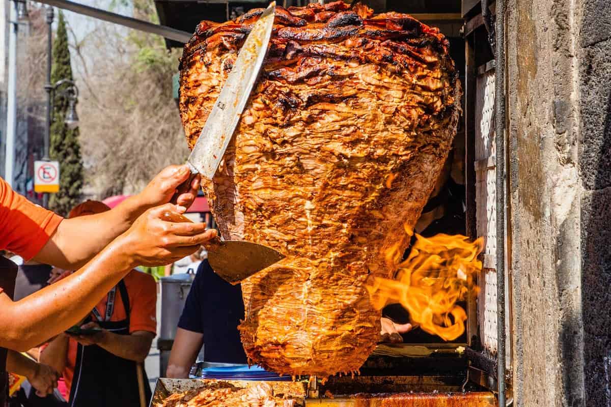 Taco maker in Mexico City preparing tacos al pastor.