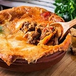 Juicy meat pot pie in a ceramic oven pot, beef stew pie with puff pastry