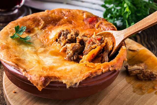 Juicy meat pot pie in a ceramic oven pot, beef stew pie with puff pastry