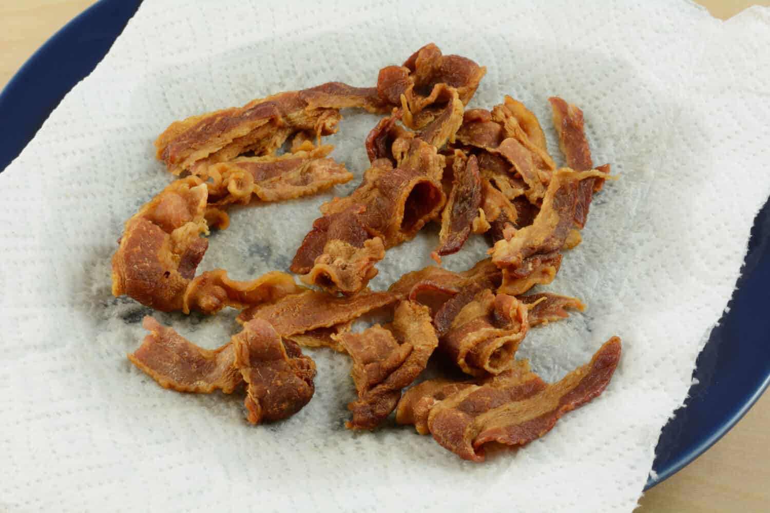 Microwaved crunchy bacon cooked on paper towel to absorb and reduce grease and fat and clean up afterwards