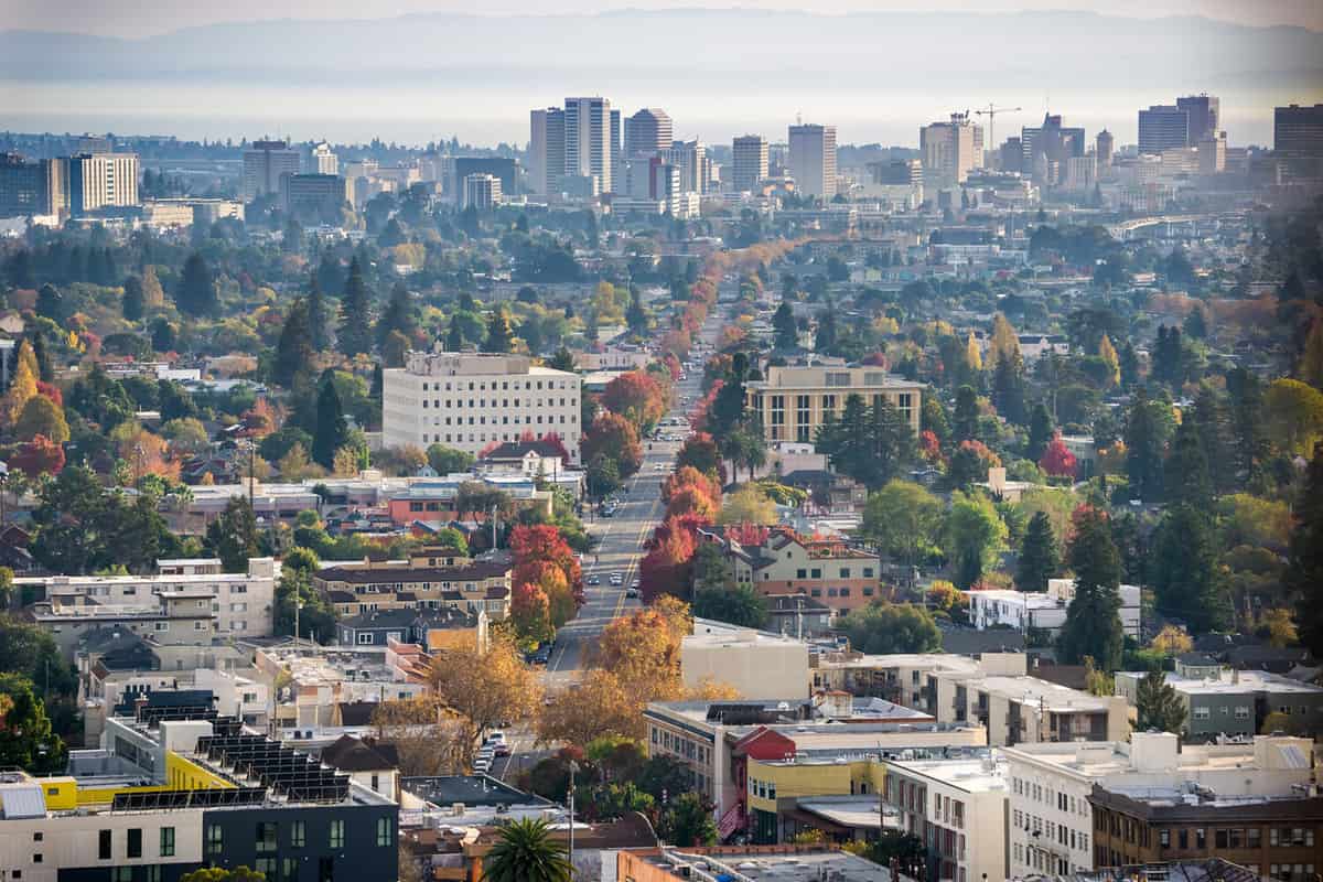 Aerial view of north Oakland on a sunny autumn evening; downtown Oakland in the background; buildings in UC Berkeley in the foreground; San Francisco bay, California