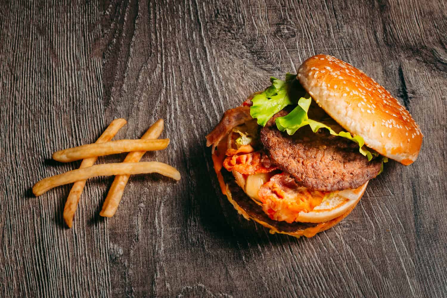 McDonald's Big Mac hamburger. French fries, hamburger on wood table