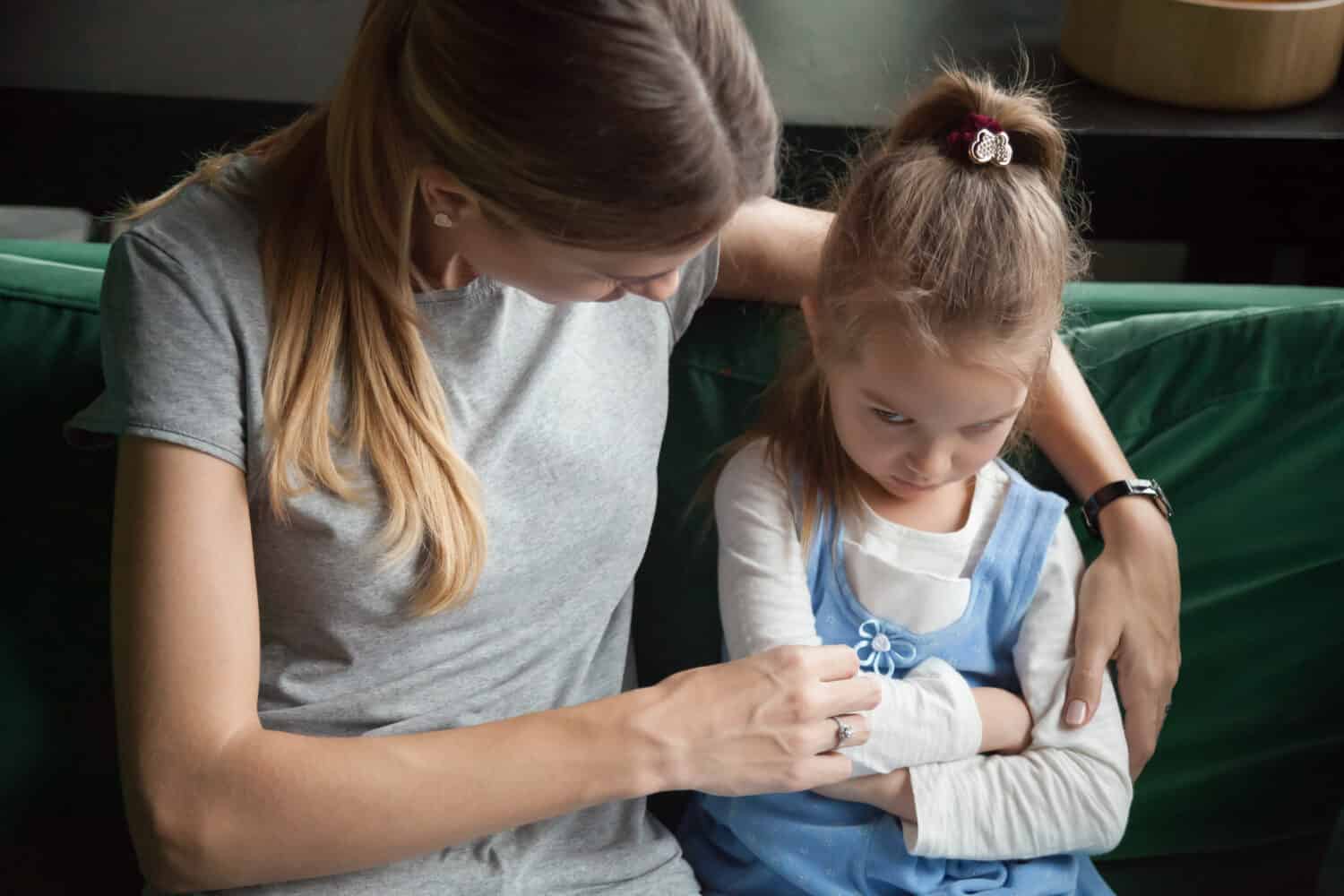 Sulky angry offended aggrieved child girl pouting ignoring avoiding mother trying to embrace and talk to upset stubborn daughter about misunderstanding problem, difficult kid insult behavior concept