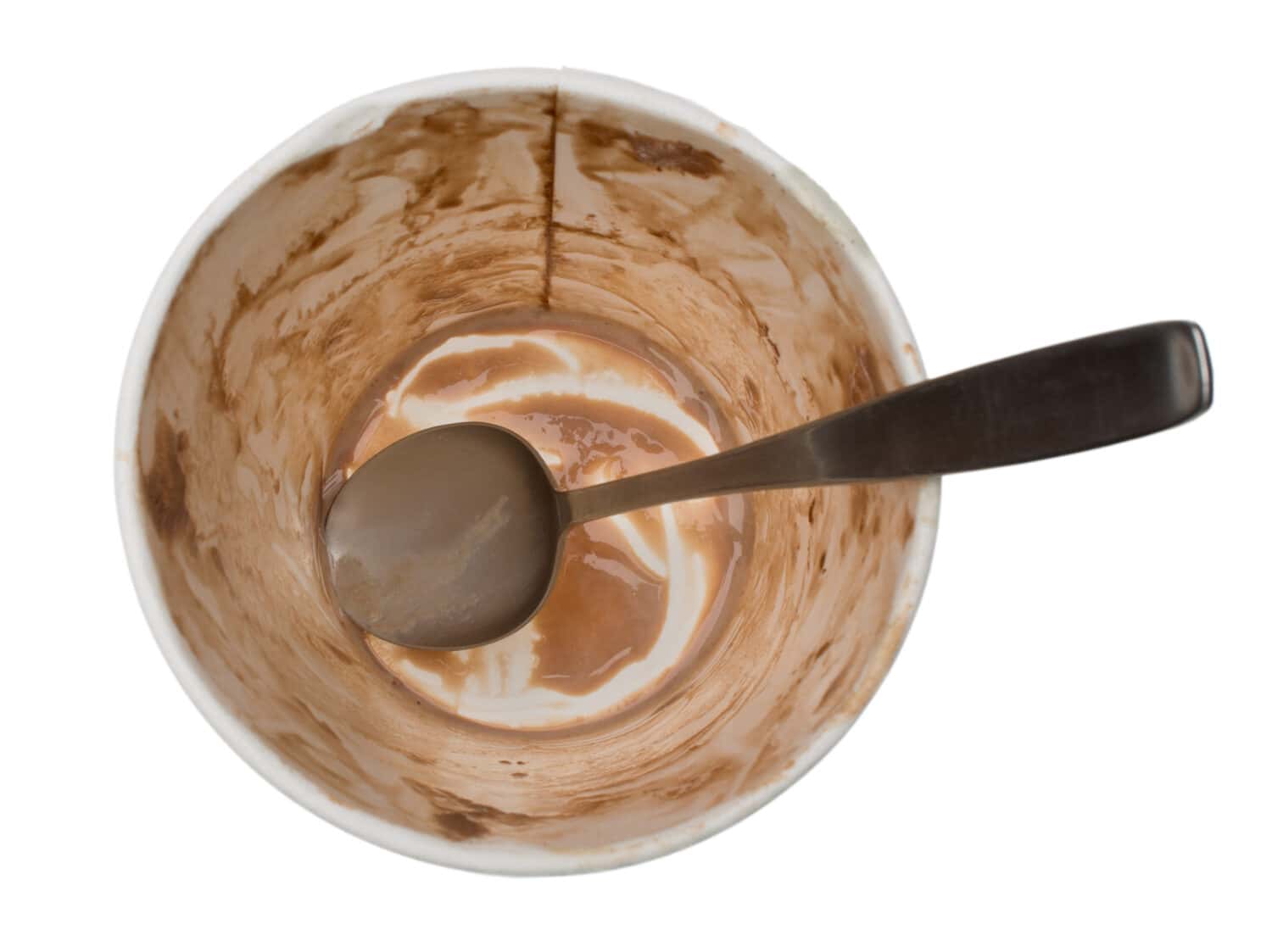 Empty ice cream container. The dirty spoon and the paper tub smeared with chocolate are all that's left of this pint of ice cream. Isolated on a white background