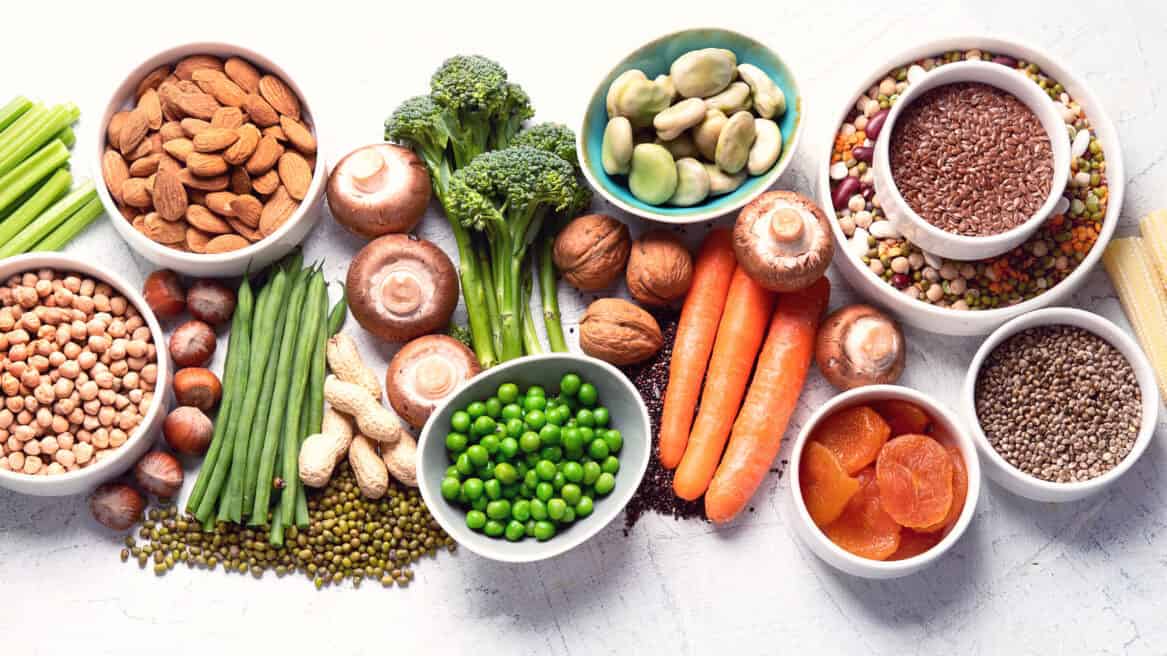 Food sources of plant based protein. Healthy diet with legumes, dried fruit, seeds, nuts and vegetables. Foods high in protein, antioxidants, vitamins and fiber. Image with copy space. Top view