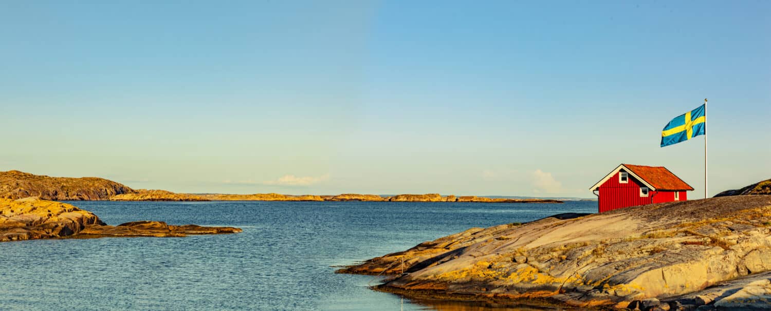 Red house in Sweden at the skerry coast with flag