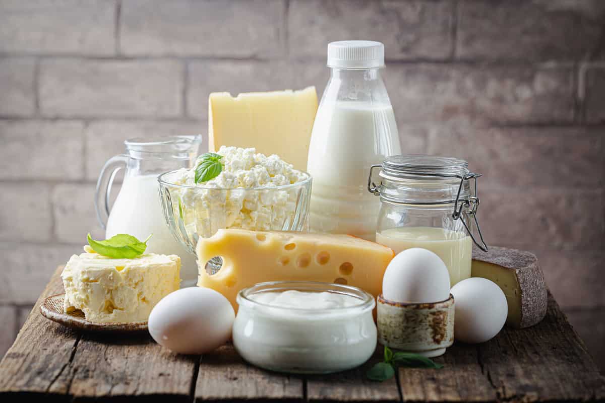 Fresh dairy products, milk, cottage cheese, eggs, yogurt, sour cream and butter on wooden table