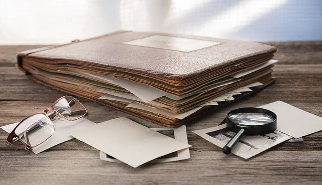 Albums with old family photos on a wooden table.