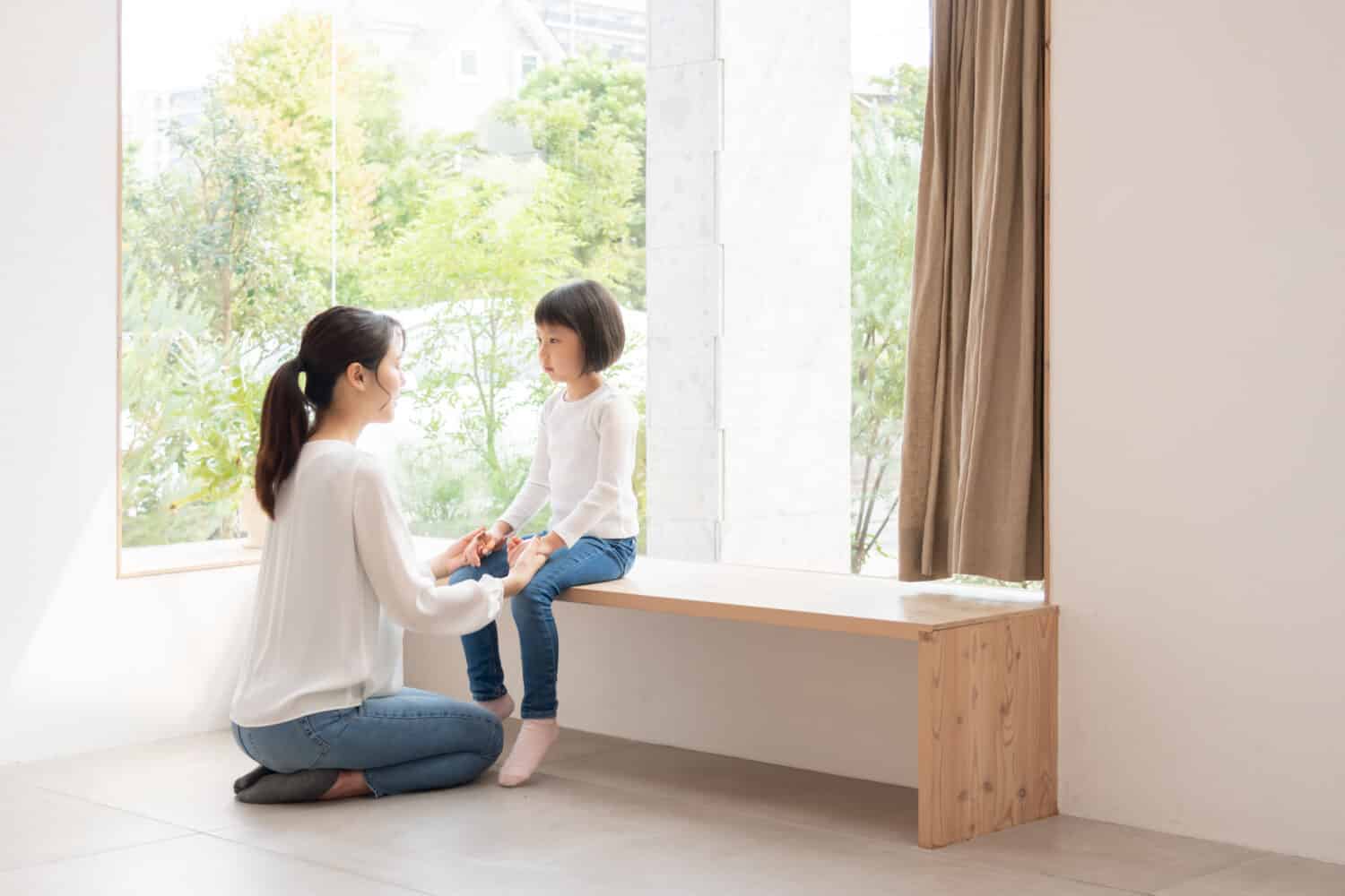 Mother comforting her daughter in the living room