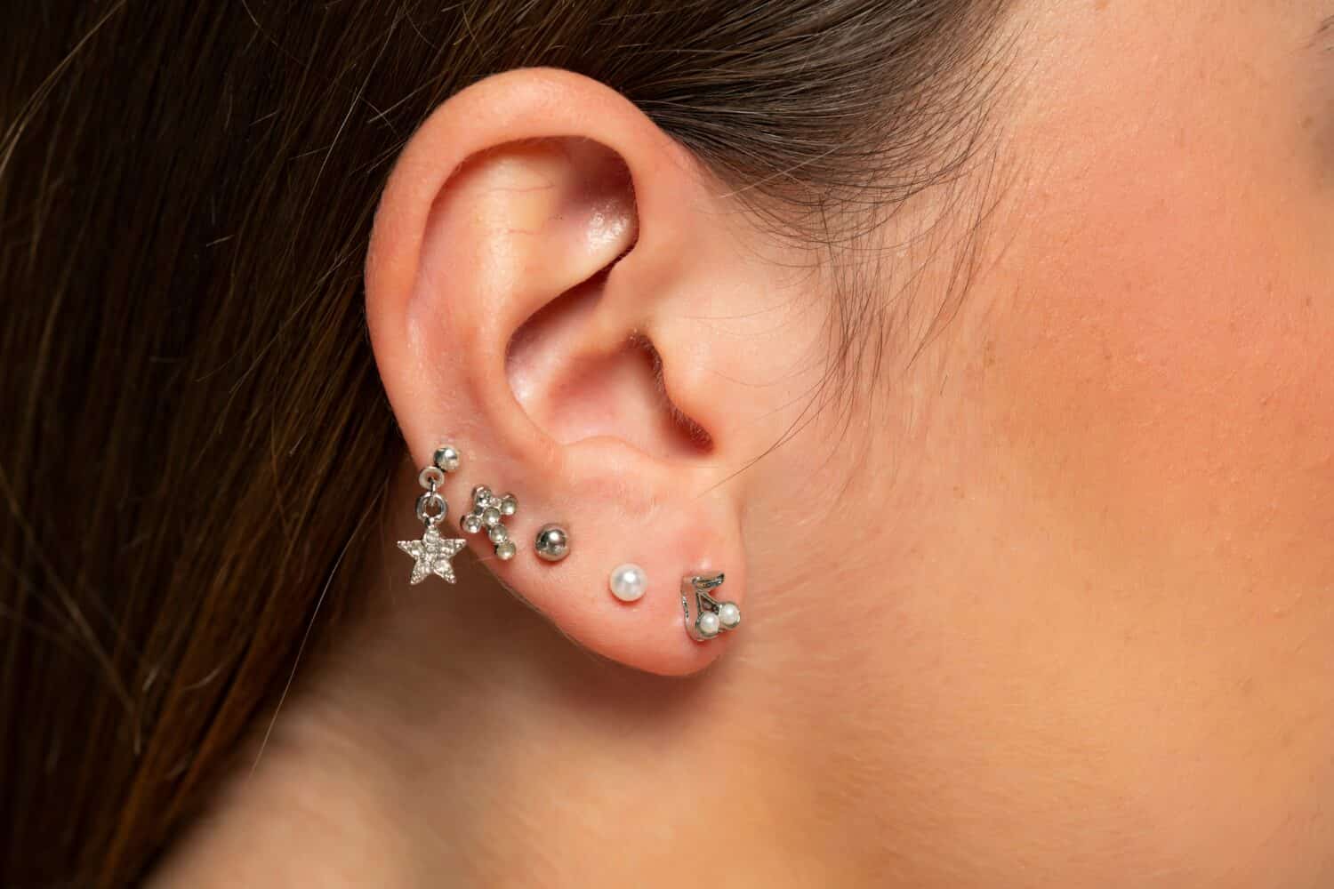 ear piercings photos.Helix piercing.Ear rings. Close up.