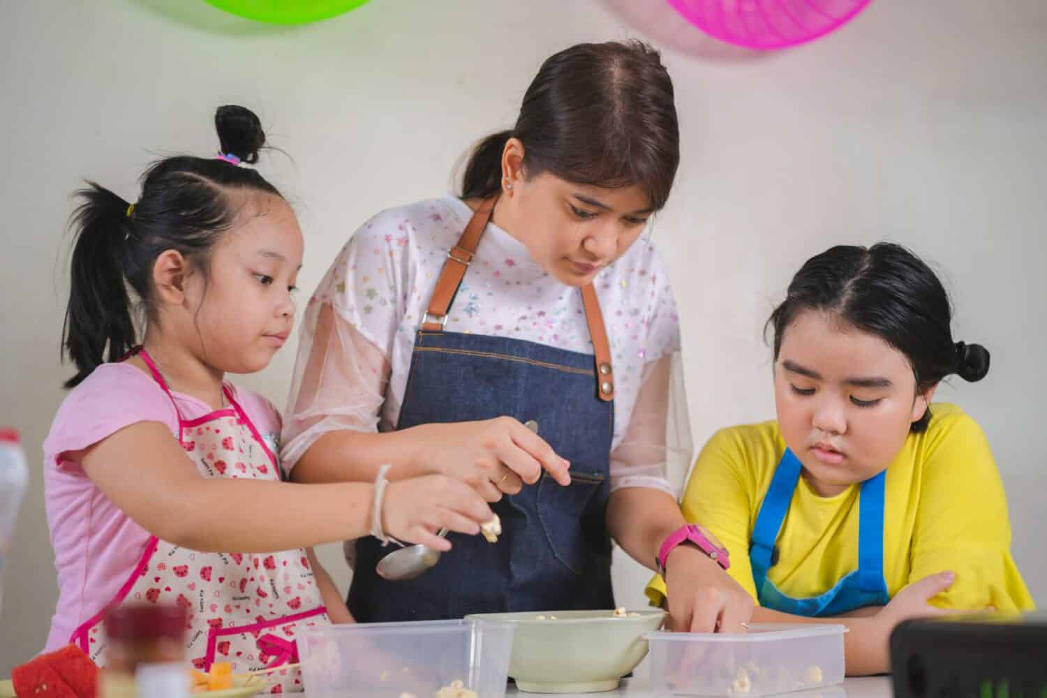 Asian mother and daughter enjoy making popcorn, Asian mom teaching daughter to learn making popcorn in real life kitchen at home