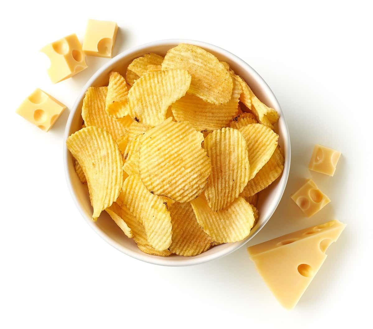 Bowl of crispy wavy potato chips or crisps with cheese flavor isolated on white background, top view