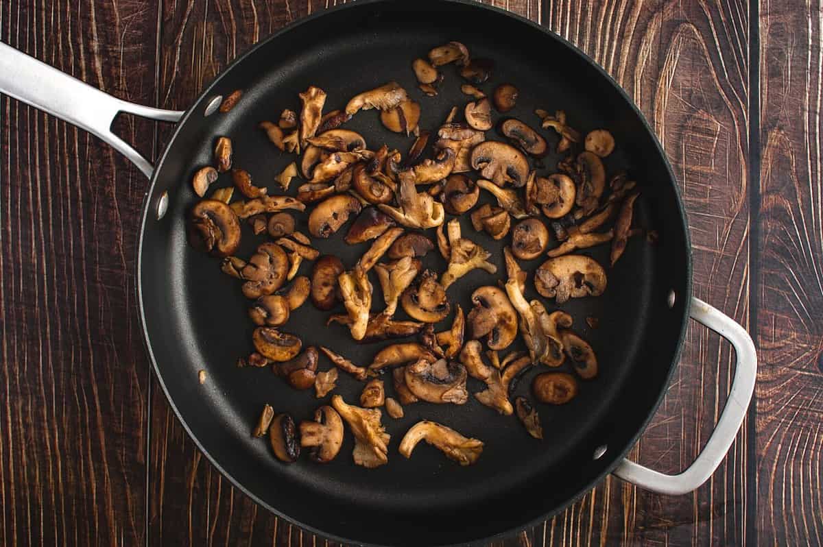 Browned Wild Mushrooms in a Non-stick Saute Pan Viewed from Above: Overhead view of oyster, shiitake, and crimini mushrooms cooked in butter