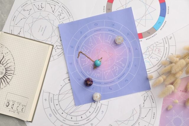 Natal charts for making forecast of fate and astrological items for fortune telling on table, flat lay