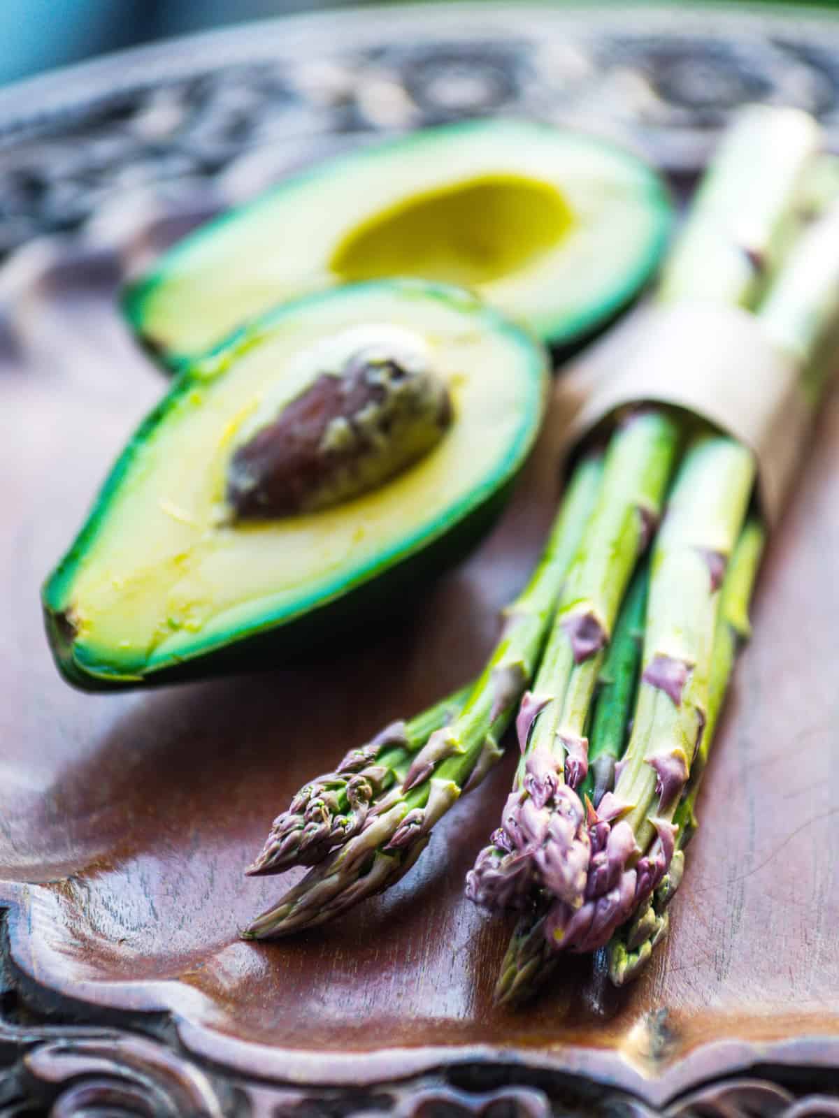 Bunch of fresh asparagus and avocado on wooden table