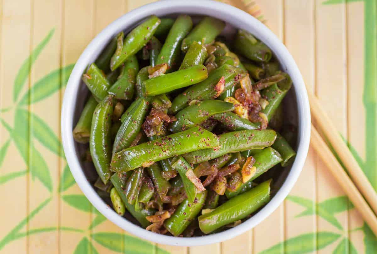 Green beans with garlic, onion and red pepper. Warm salad. The garnish. Dish Oriental cuisine. Selective focus