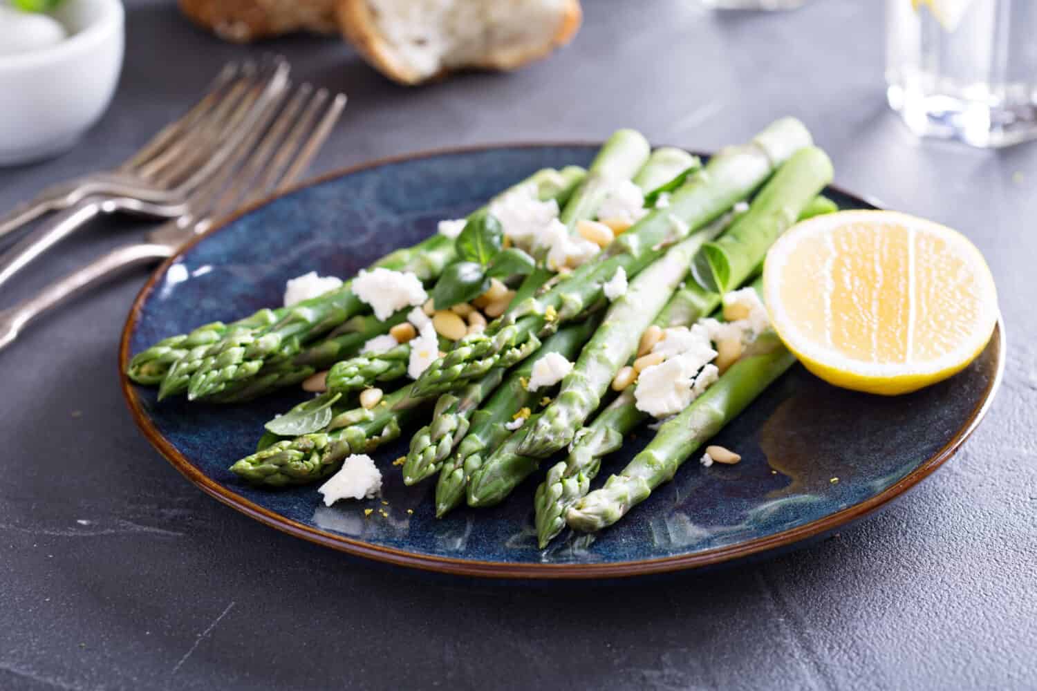 Warm salad with asparagus, feta cheese, pine nuts and lemon