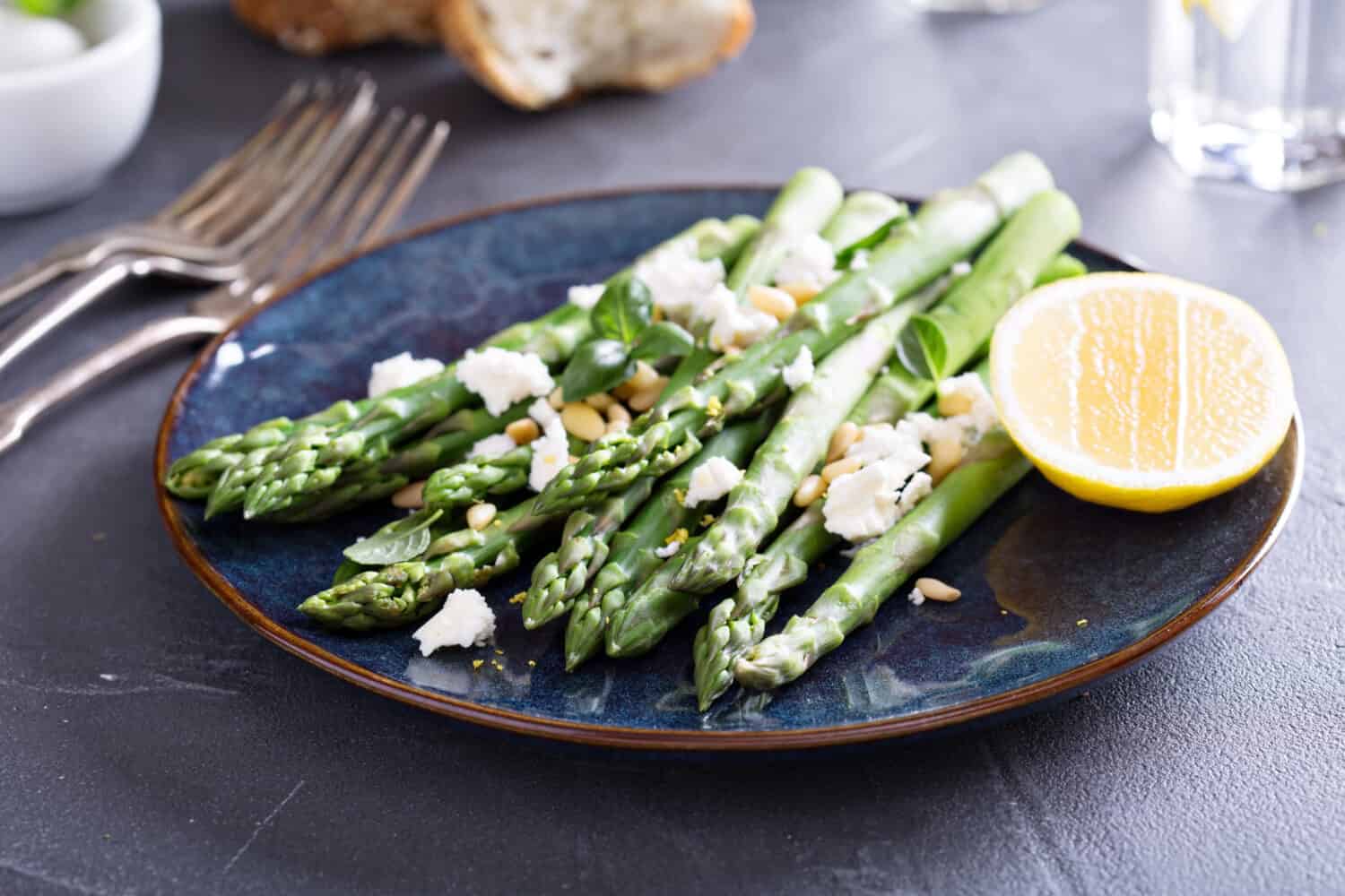 Warm salad with asparagus, feta cheese, pine nuts and lemon