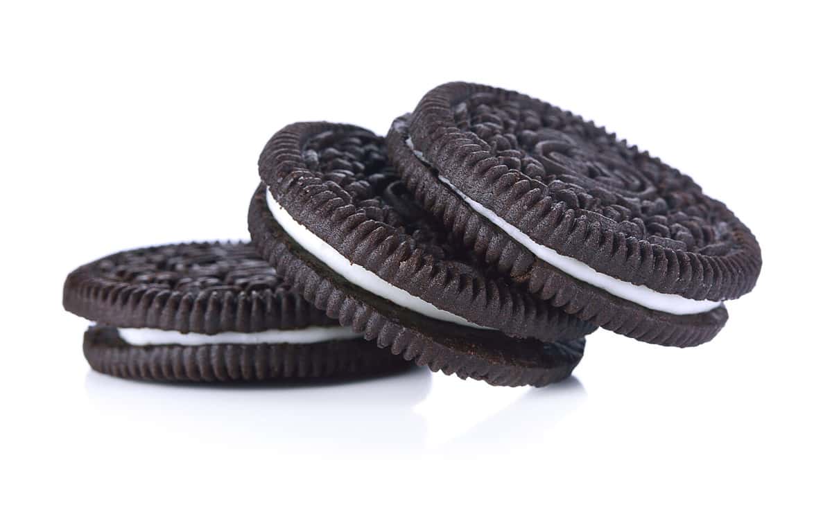 Chocolate cookies with cream filling tower isolated on white background.