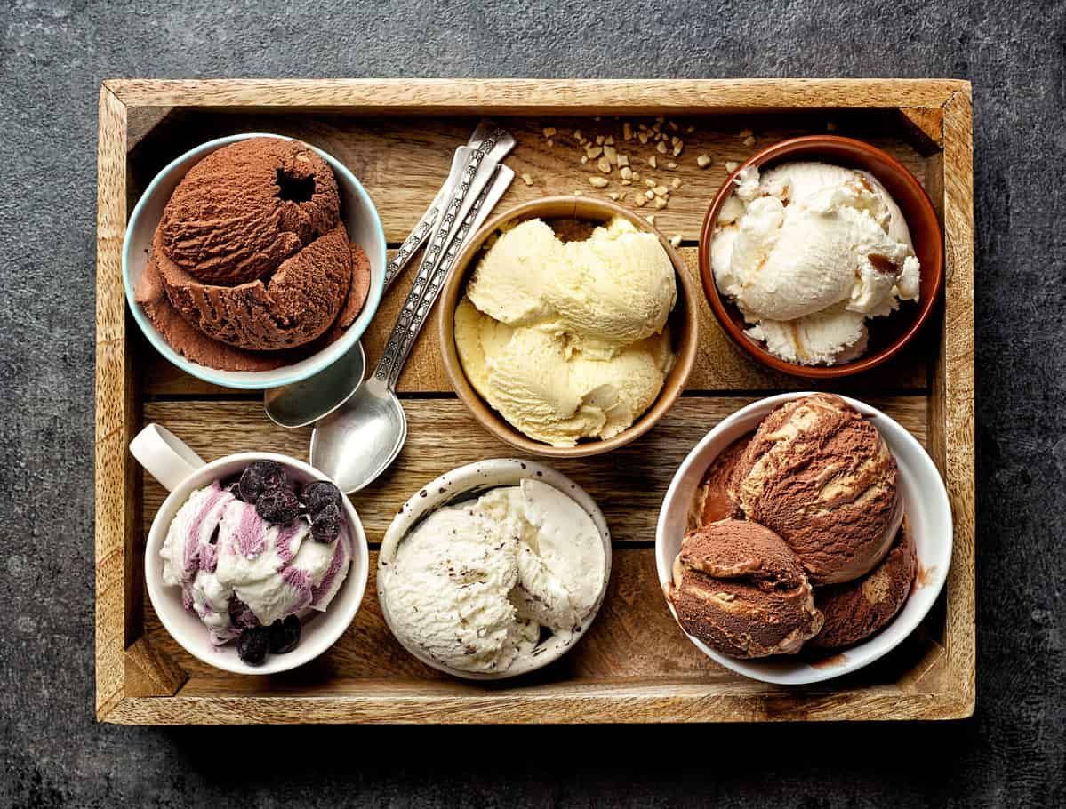 bowls of various ice creams on dark gray table, top view