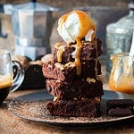 Chocolate brownies with salted caramel, vanilla ice cream and walnuts