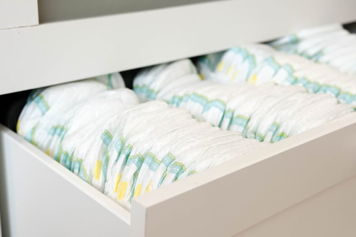 Stack of baby disposable diapers and Pacifier over white background