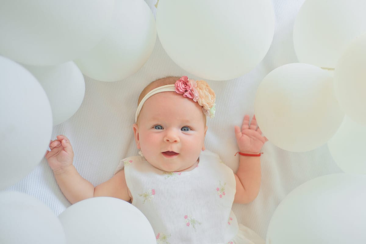 Waiting for a baby. Small girl. Happy birthday. Portrait of happy little child in white balloons. Sweet little baby. New life and birth. Childhood happiness. Family. Child care. Childrens day.