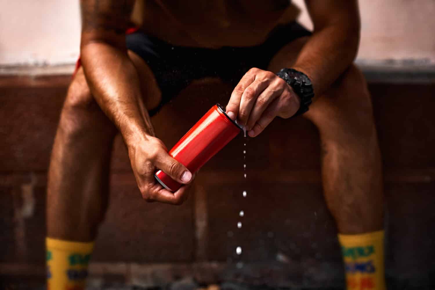 guy holding aluminum can red with beverage, closeup. Mockup for design