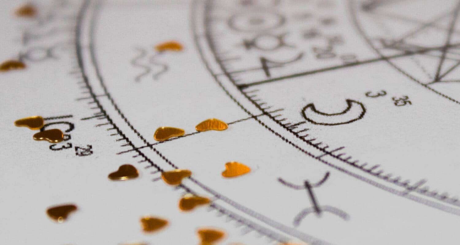 Detail of printed natal chart with astrology moon and heart shaped golden sequins