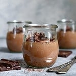 Delicious chocolate mousse in a vintage glasse jar on a light grey slate, stone or concrete background.