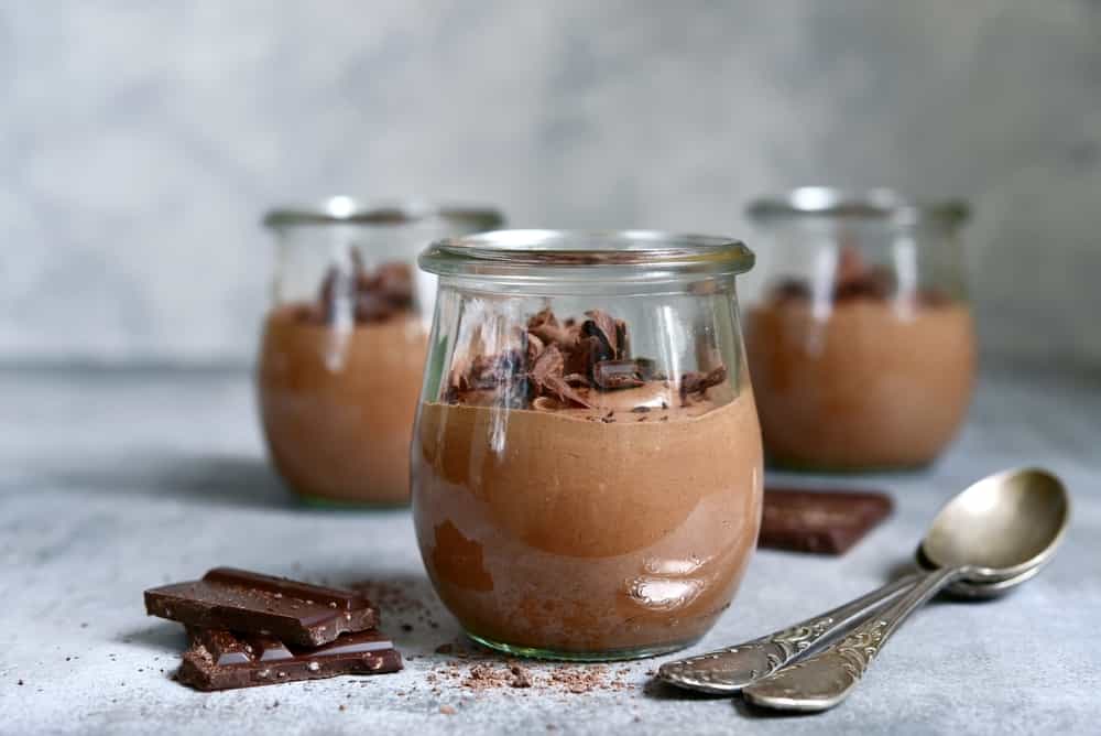Delicious chocolate mousse in a vintage glasse jar on a light grey slate, stone or concrete background.