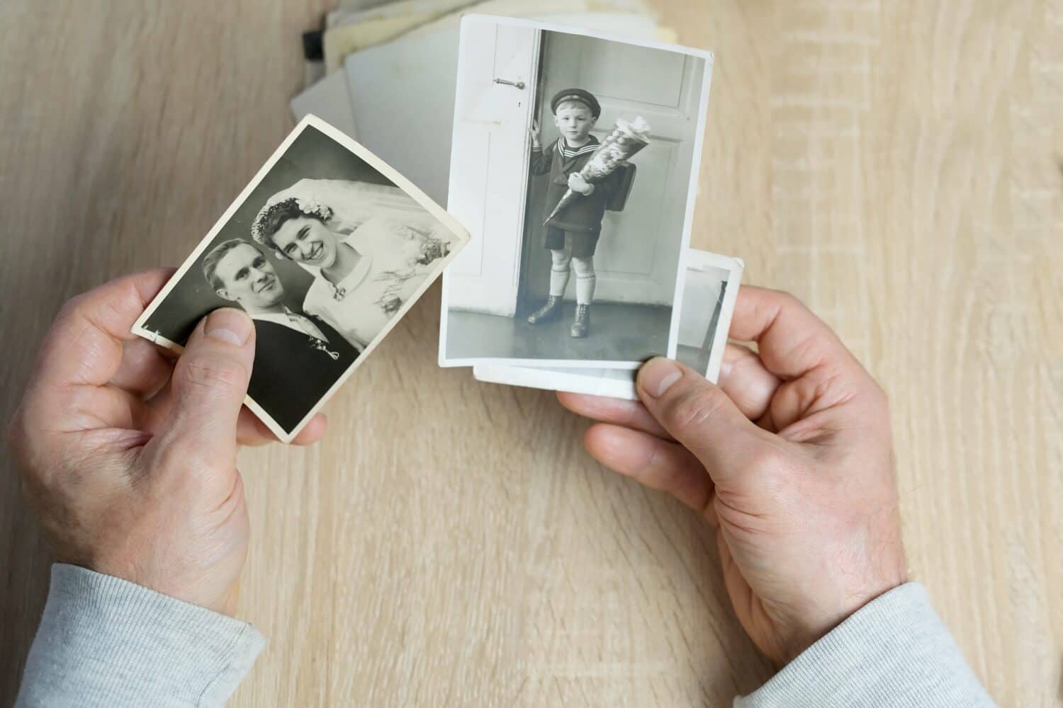 closeup male hand holding old vintage photos of 1940-1950, concept of family tree, genealogy, childhood memories, memory of ancestors