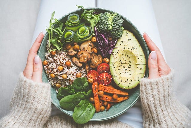 Woman holding plate with vegan or vegetarian food. Healthy plant based diet. Healthy dinner or lunch. Buddha bowl with fresh vegetables. Healthy eating