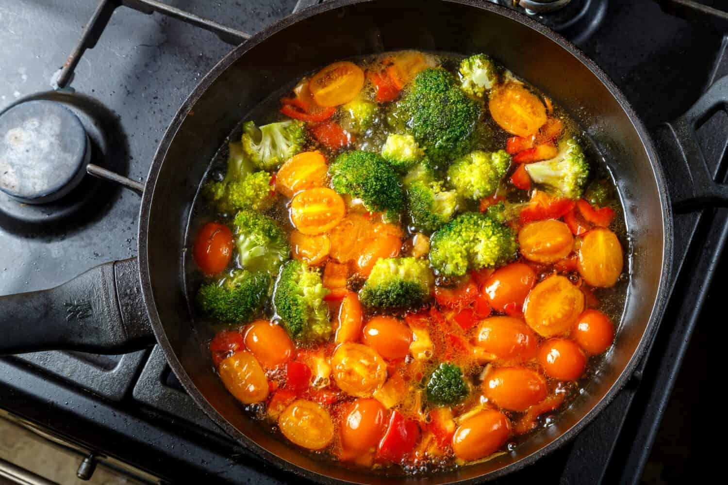 Stewed vegetables beans broccoli tomatoes stewed with spices in a frying pan. horizontal photo