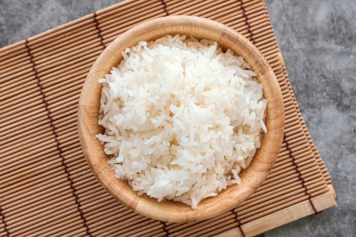 Top Table View Of Thai Jasmine Rice in Wooden Bowl, staple food of Thailand and Asia, providing energy in every meal.