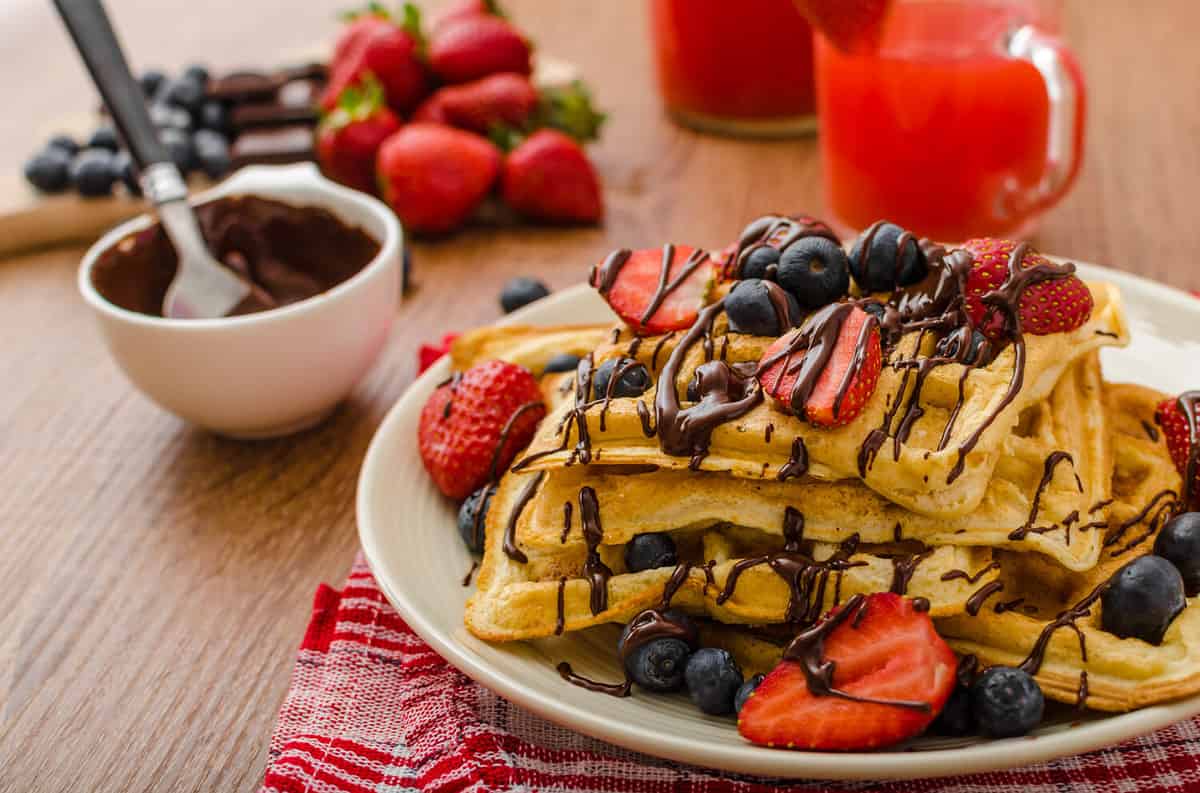 Belgian waffles with blueberries, strawberries covered with chocolate