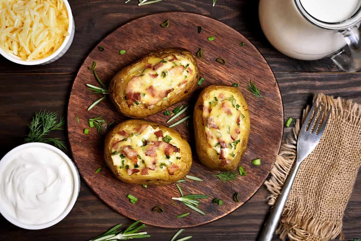 Baked stuffed potatoes with bacon, green onion and cheese, top view.