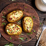 Baked stuffed potatoes with bacon, green onion and cheese, top view.