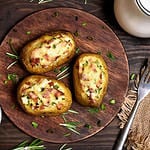 Baked stuffed potatoes with bacon, green onion and cheese, top view.