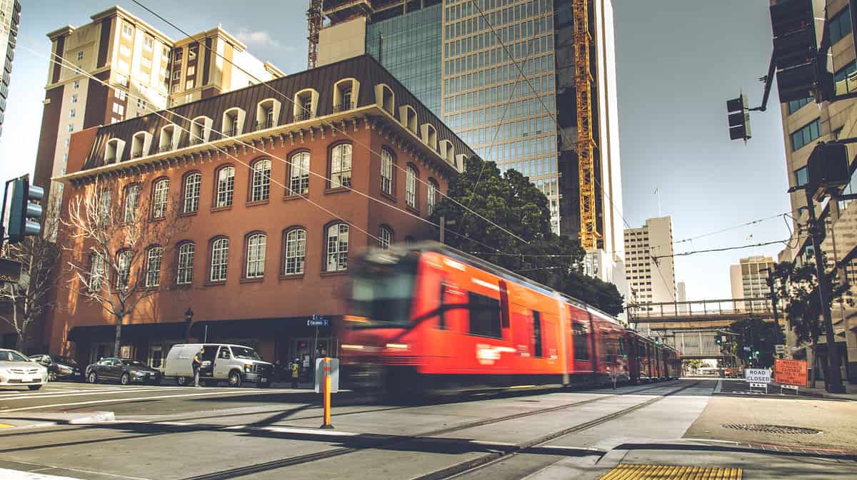 Red Trolley through the building from sidewalk street in downtown San Diego city, USA