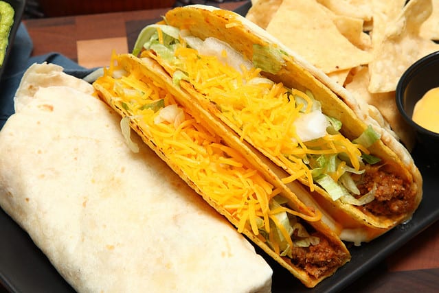 Burrito, Taco, Gordita Crunch and Nachos with Cheese Sauce on Dish.
