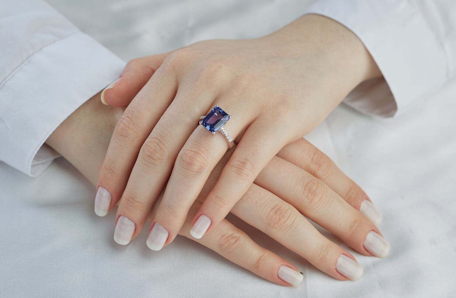 The blue stone diamond ring is on a lady finger. A very expensive custom ring.