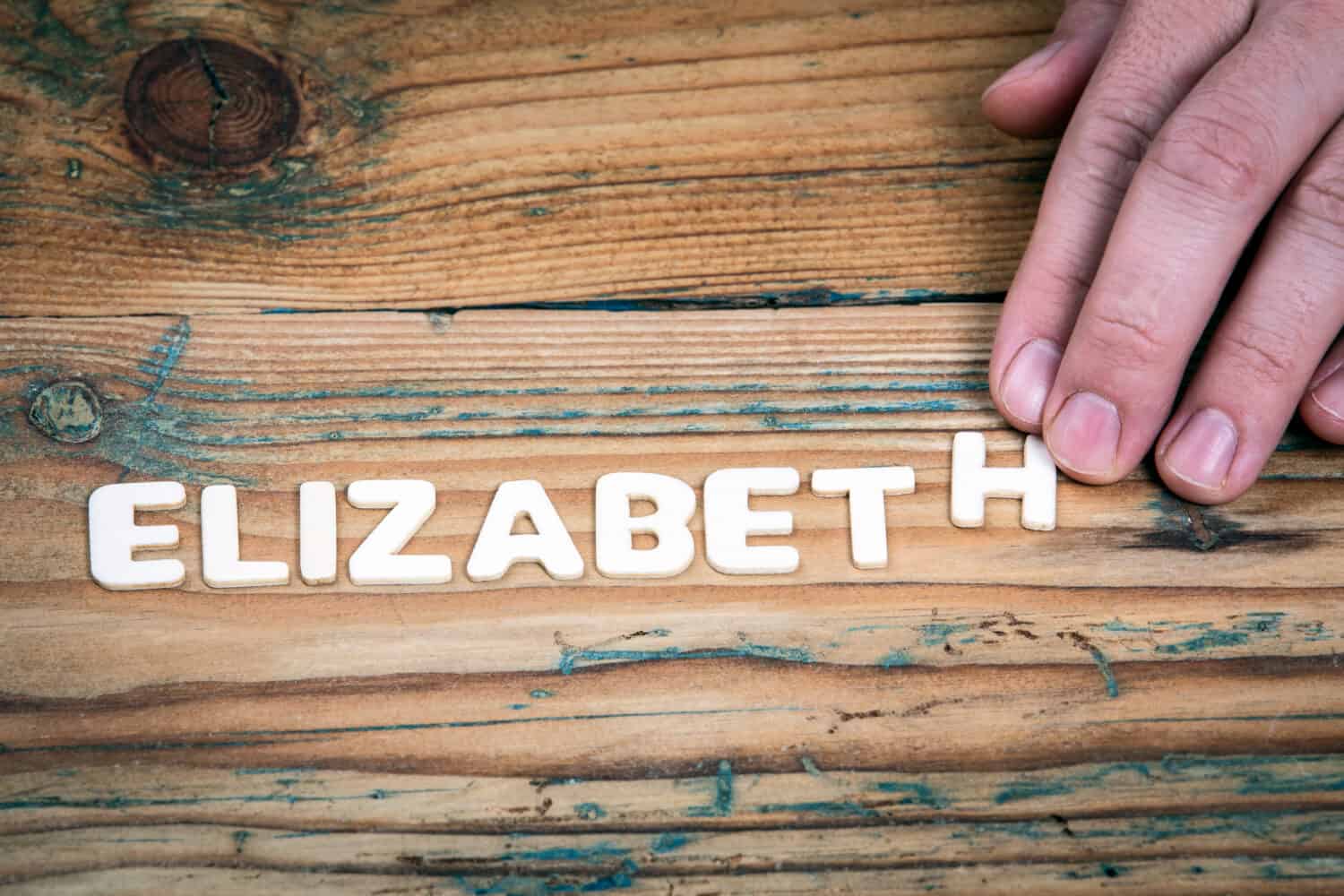 Elizabeth. Name of women and girls. White letters of the alphabet on a wooden background.