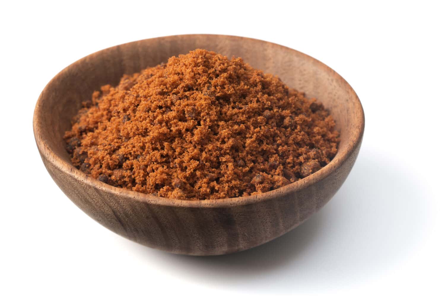brown granulated sugar in the wooden bowl, isolated on pure white background