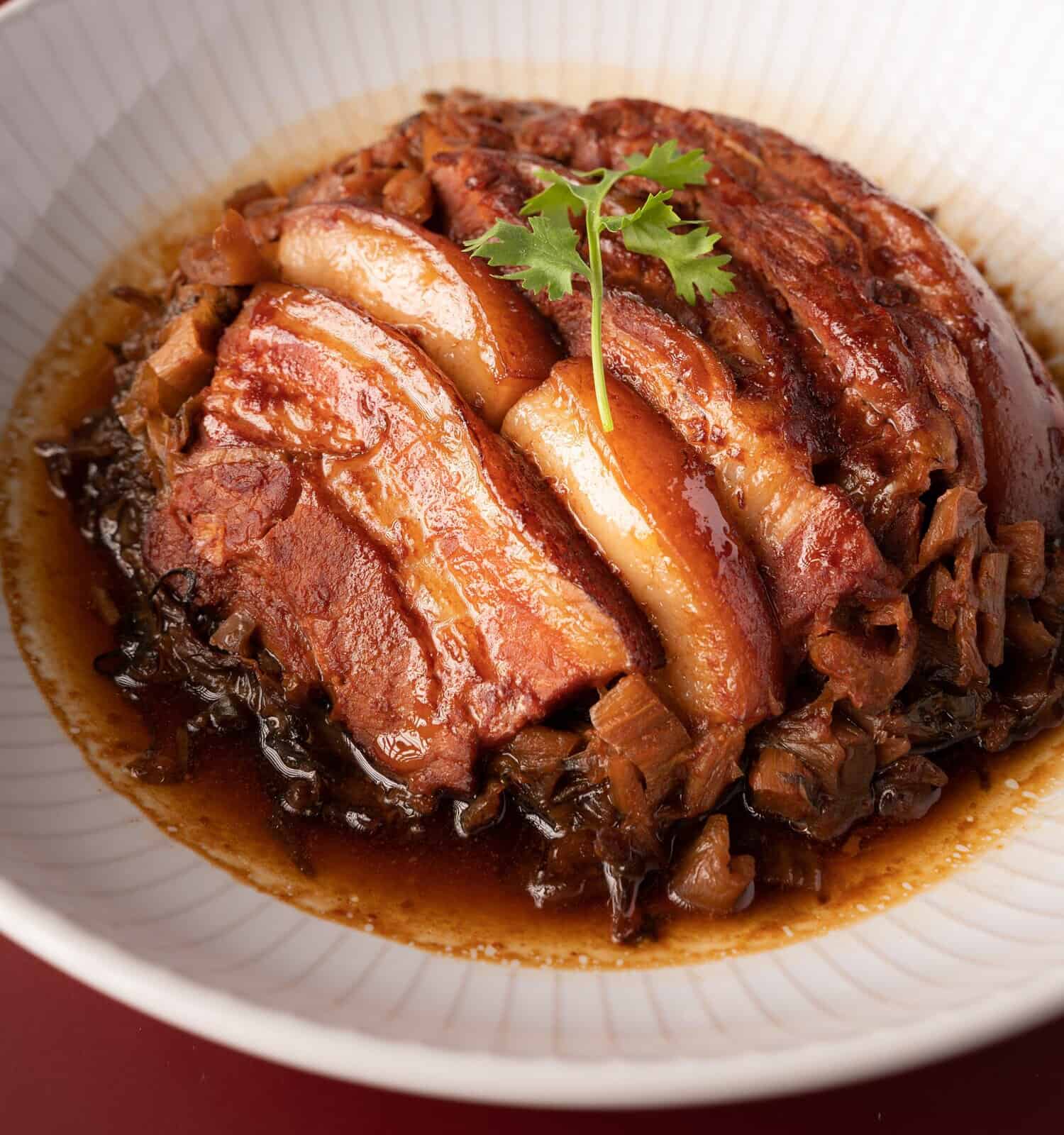 Braised Pork Belly with Preserved Mustard Green with rice on red background