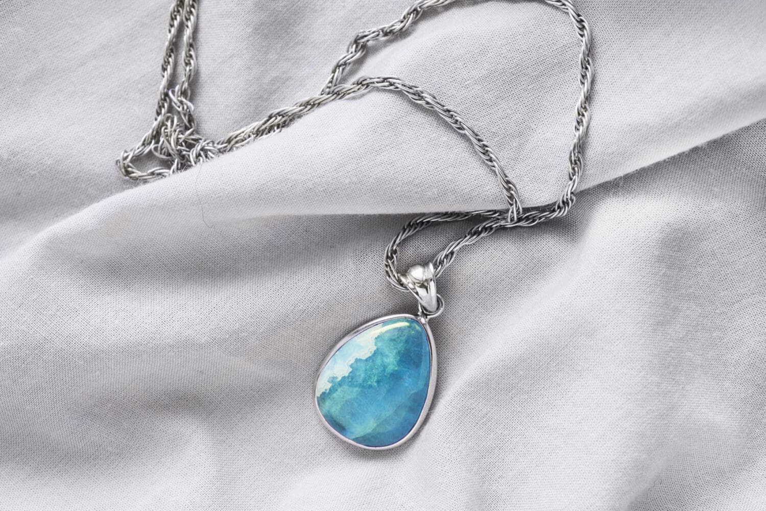 Aquamarine pendant on blank dray cloth as a background