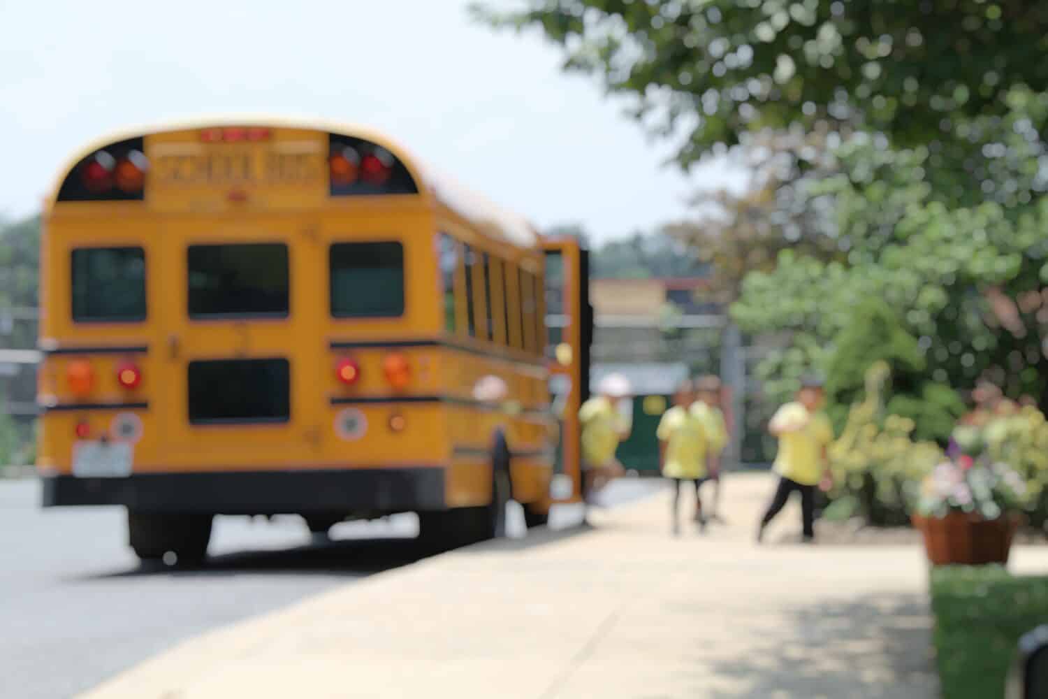 BLUR IMAGE OF YELLOW SCHOOL BUS WITH YOUNG CHILDREN, MARYLAND, USA