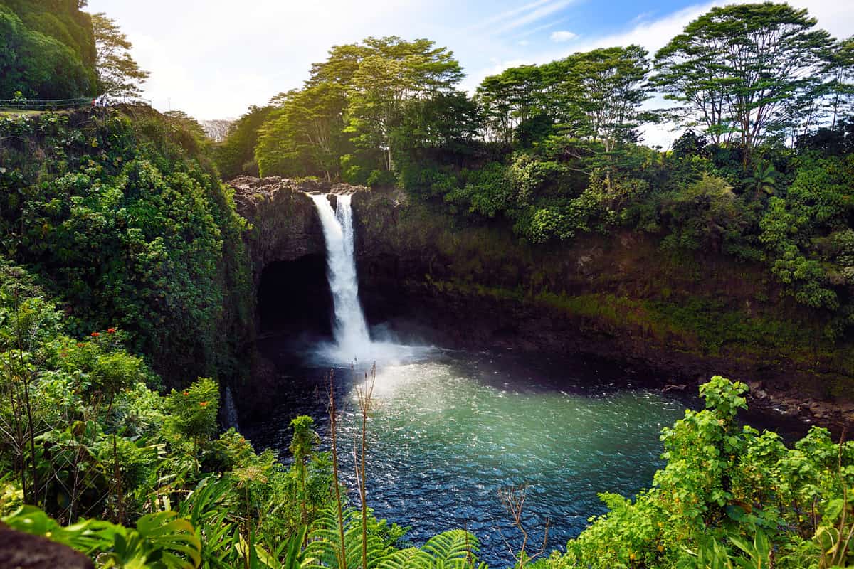 Majesitc Rainbow Falls waterfall in Hilo, Wailuku River State Park, Hawaii. The falls flows over a natural lava cave, the mythological home to Hina, an ancient Hawaiian goddess.