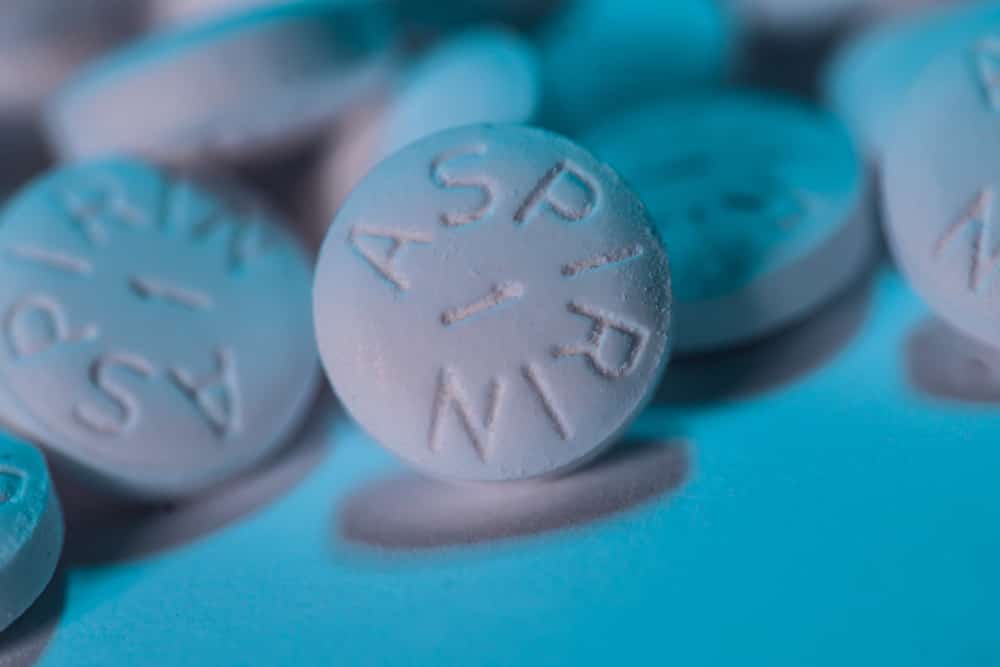 White Aspirin macro shot on aqua blue background